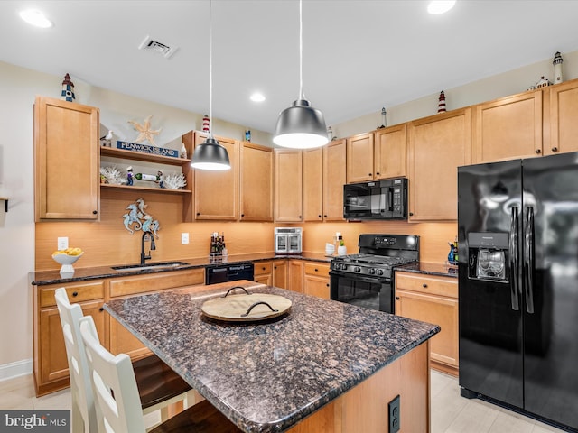 kitchen with pendant lighting, black appliances, sink, light brown cabinetry, and a kitchen island