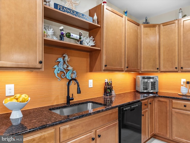 kitchen featuring black dishwasher, dark stone countertops, and sink