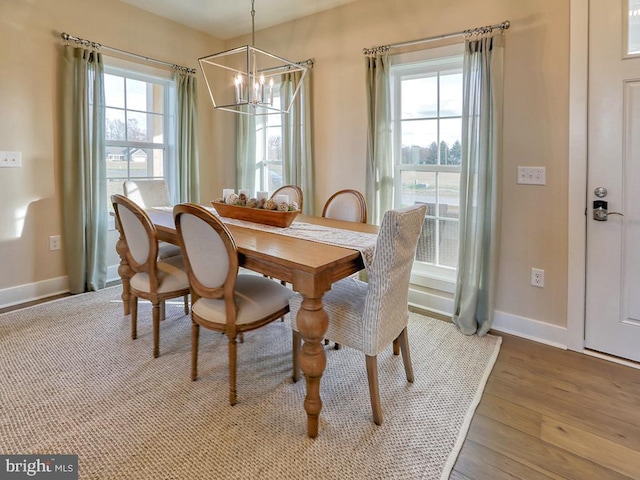 dining space featuring light hardwood / wood-style floors, a healthy amount of sunlight, and a notable chandelier