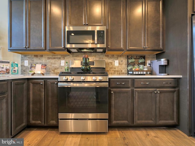 kitchen with stainless steel appliances, tasteful backsplash, light hardwood / wood-style flooring, and dark brown cabinetry