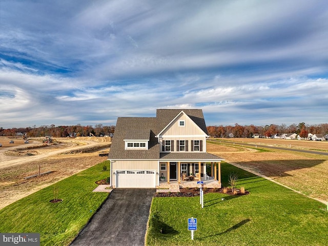 view of front of home featuring a garage, a front yard, a rural view, and a porch