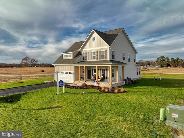 view of front of property featuring a front lawn, central AC unit, and covered porch