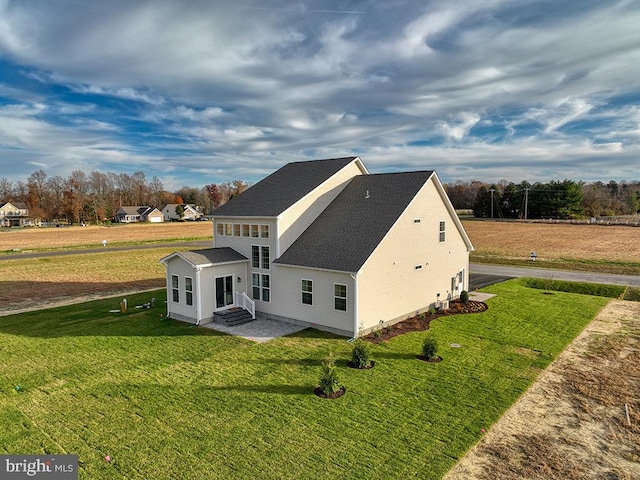 rear view of property with a lawn and a patio