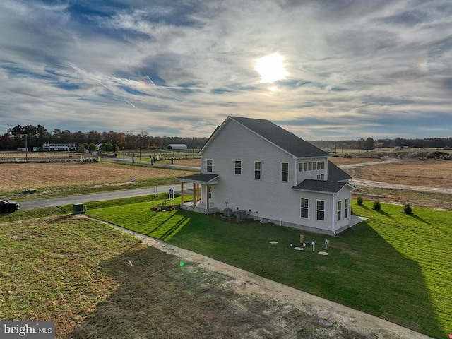 view of property exterior with a rural view and a lawn