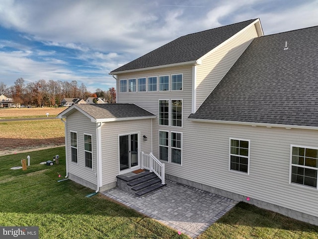 rear view of property featuring a patio area and a yard