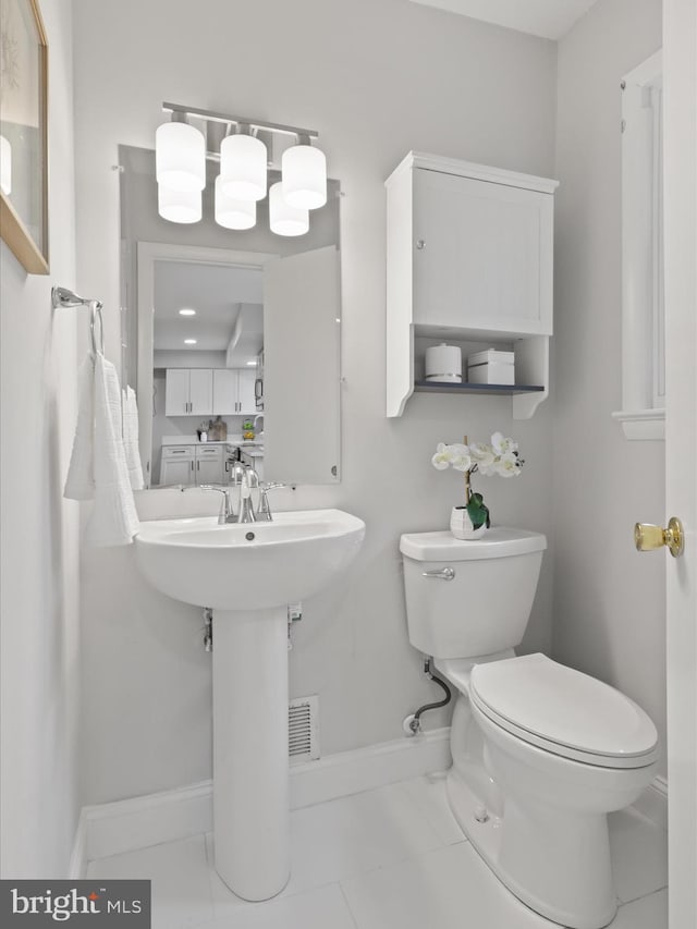 half bathroom with toilet and baseboards