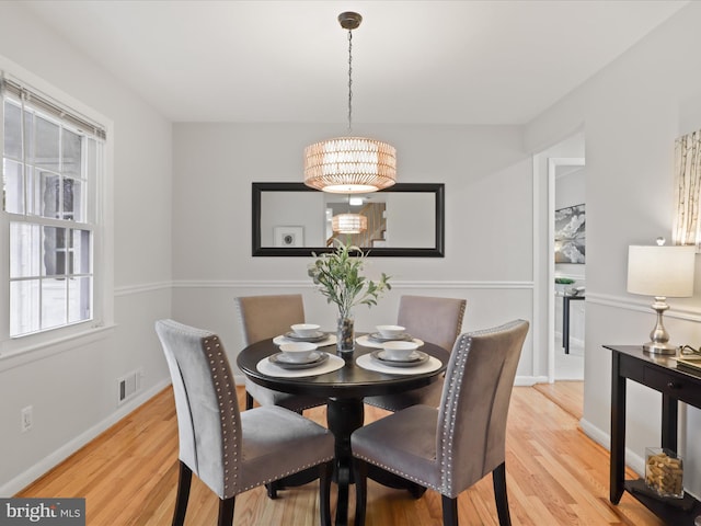 dining area featuring light wood-type flooring, visible vents, and baseboards