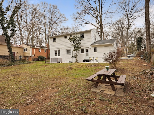 rear view of house featuring a lawn and a patio