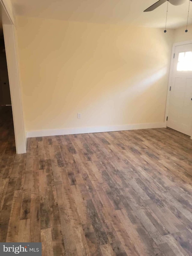 spare room with dark wood-type flooring and ceiling fan