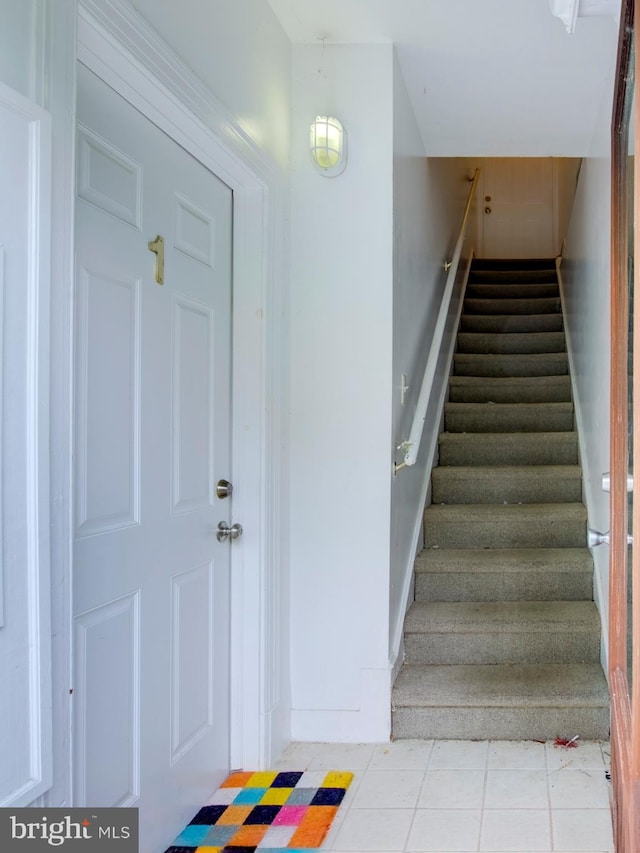 stairway with tile patterned floors