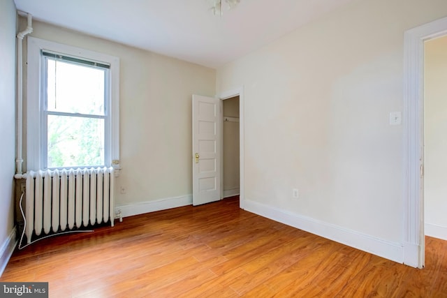 empty room featuring hardwood / wood-style floors and radiator