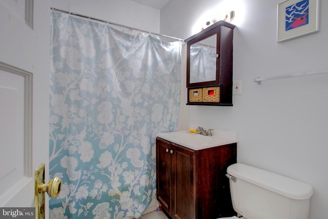 bathroom featuring vanity, a shower with shower curtain, and toilet