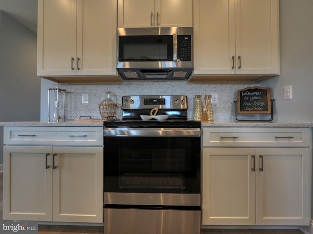 kitchen with white cabinetry, stainless steel appliances, and tasteful backsplash