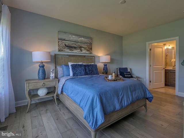 bedroom featuring ensuite bath and light hardwood / wood-style flooring