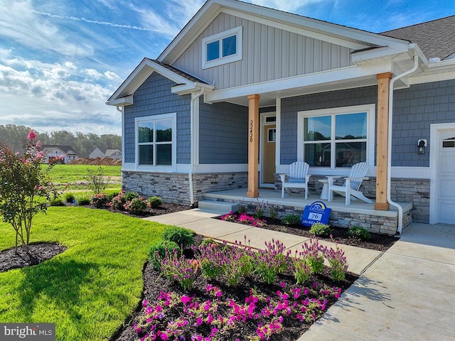 entrance to property with a porch and a lawn