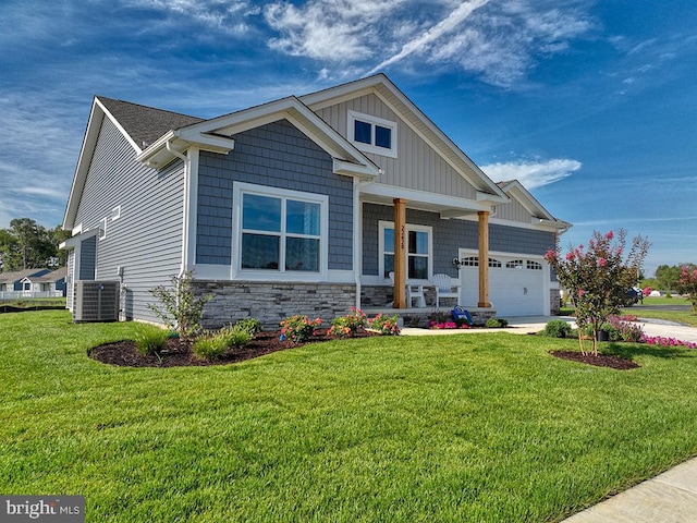 craftsman-style house featuring central air condition unit, a front lawn, and a garage