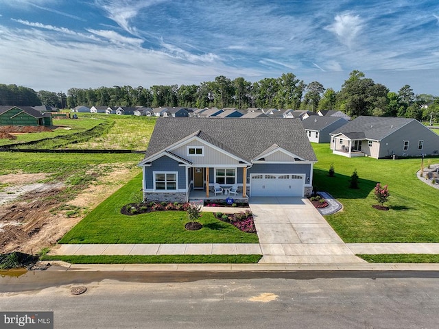 view of front of home featuring a garage, a front yard, and a porch