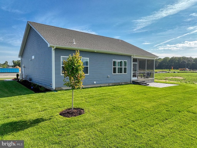 back of property with a lawn and a sunroom