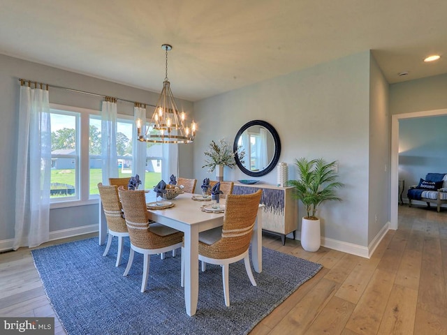 dining space featuring light wood-type flooring and a notable chandelier