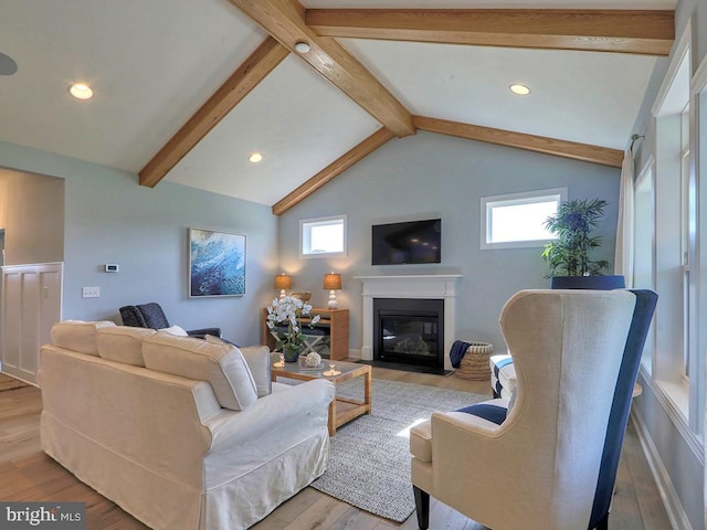 living room with lofted ceiling with beams, light hardwood / wood-style flooring, and plenty of natural light