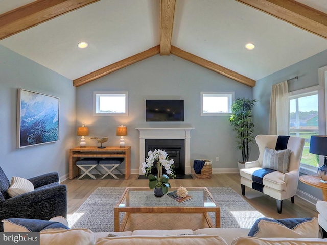 living room with lofted ceiling with beams, light hardwood / wood-style flooring, and a healthy amount of sunlight