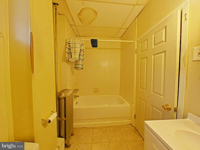 bathroom with vanity, tiled shower / bath, and radiator