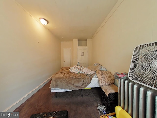 carpeted bedroom with ornamental molding and radiator