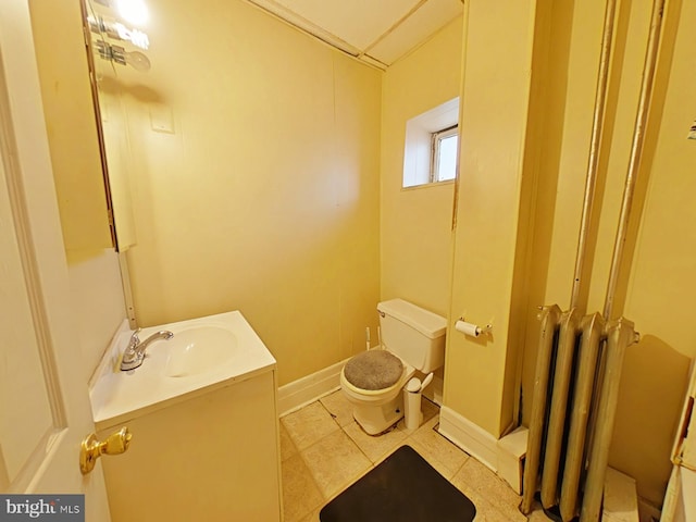 bathroom featuring vanity, tile patterned floors, toilet, and radiator