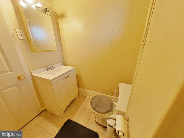 bathroom with toilet, vanity, and tile patterned flooring