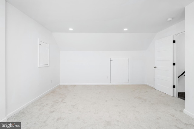 carpeted spare room featuring vaulted ceiling