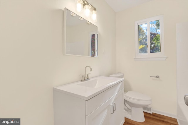 bathroom with hardwood / wood-style floors, vanity, and toilet