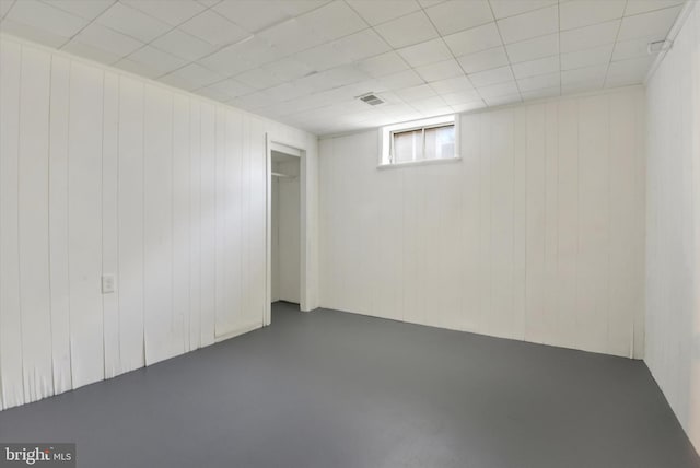 basement featuring wood walls