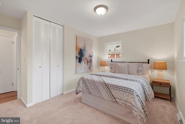 bedroom featuring a closet and light colored carpet