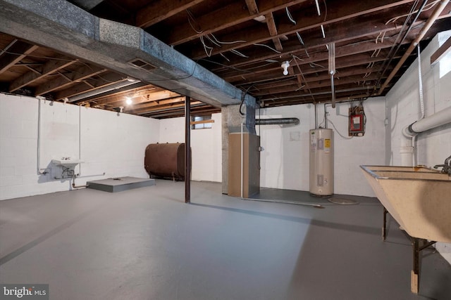 basement featuring electric water heater and sink