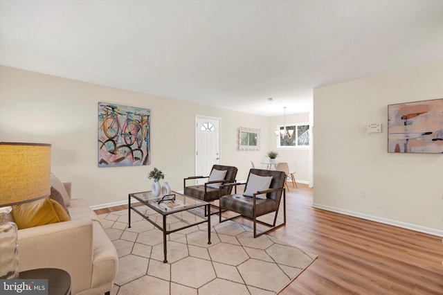 living room featuring light wood-type flooring and an inviting chandelier