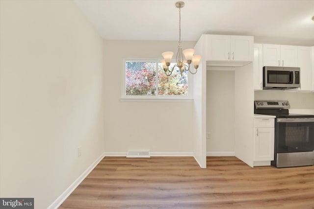 kitchen featuring hanging light fixtures, stainless steel appliances, an inviting chandelier, white cabinets, and light wood-type flooring