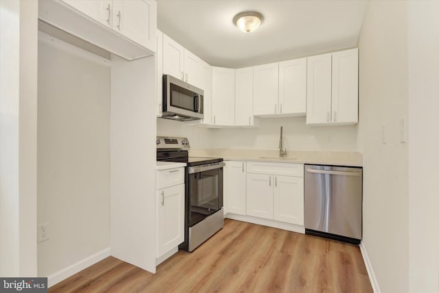 kitchen with white cabinets, stainless steel appliances, light hardwood / wood-style floors, and sink