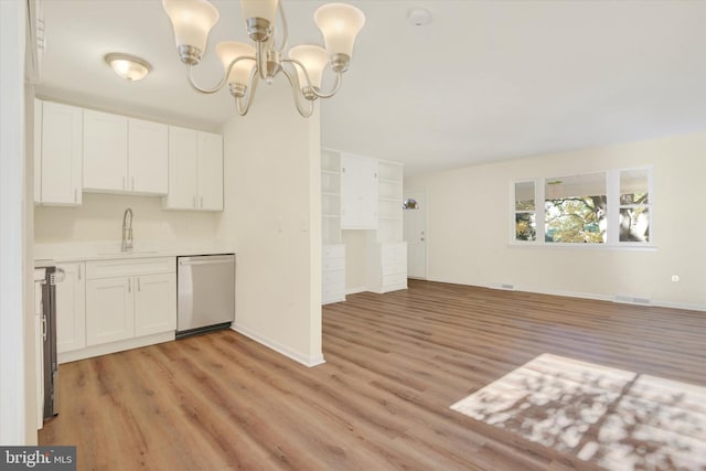 kitchen with stainless steel dishwasher, sink, light hardwood / wood-style flooring, an inviting chandelier, and white cabinets