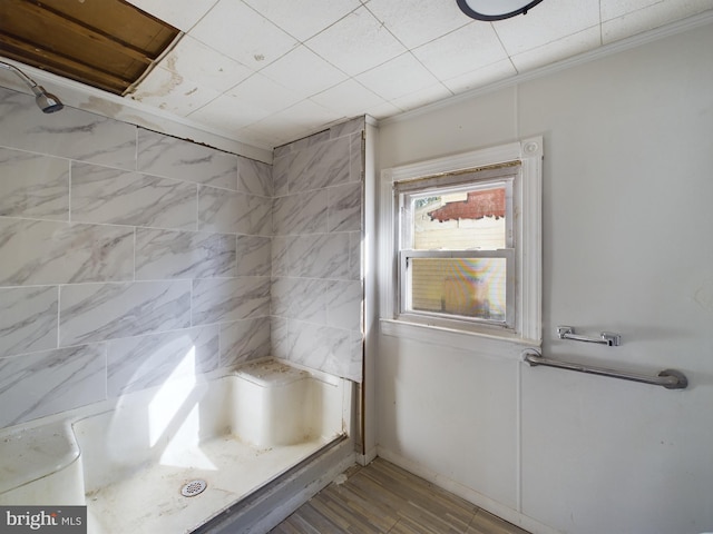 bathroom with hardwood / wood-style floors, crown molding, and walk in shower