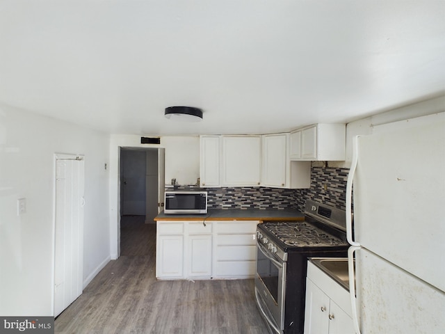 kitchen featuring appliances with stainless steel finishes, hardwood / wood-style flooring, white cabinets, and tasteful backsplash