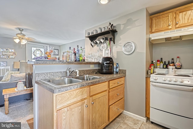 kitchen featuring kitchen peninsula, ceiling fan, light tile patterned flooring, white range oven, and sink