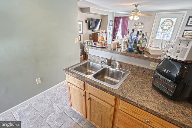 kitchen featuring ceiling fan, light tile patterned flooring, and sink