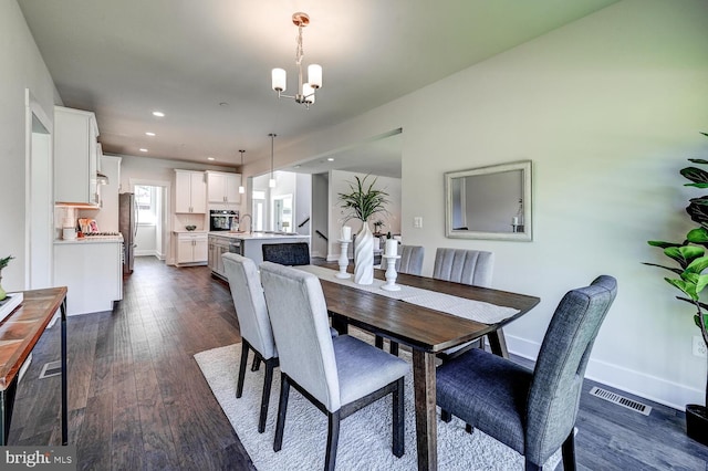 dining room with an inviting chandelier and dark hardwood / wood-style flooring