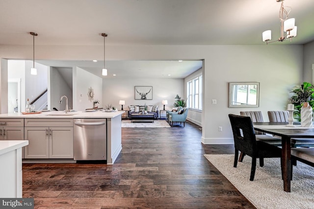 kitchen featuring dark wood-type flooring, sink, pendant lighting, stainless steel dishwasher, and white cabinets