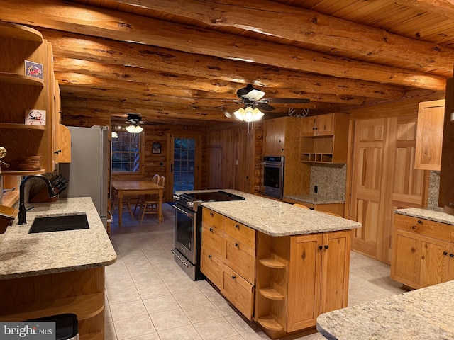 kitchen with light stone counters, sink, a center island, and appliances with stainless steel finishes