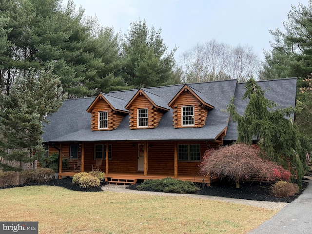 log home featuring a porch and a front yard