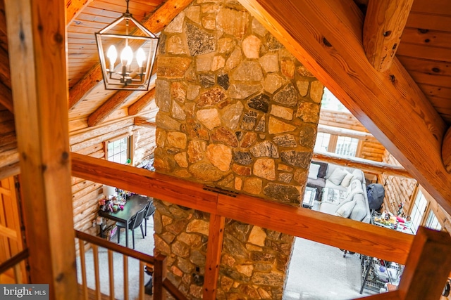 interior details featuring log walls, beam ceiling, and a notable chandelier