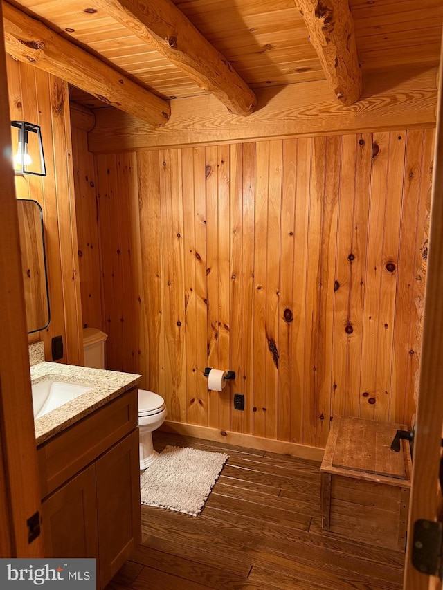 bathroom featuring beamed ceiling, wood-type flooring, wooden walls, and wooden ceiling