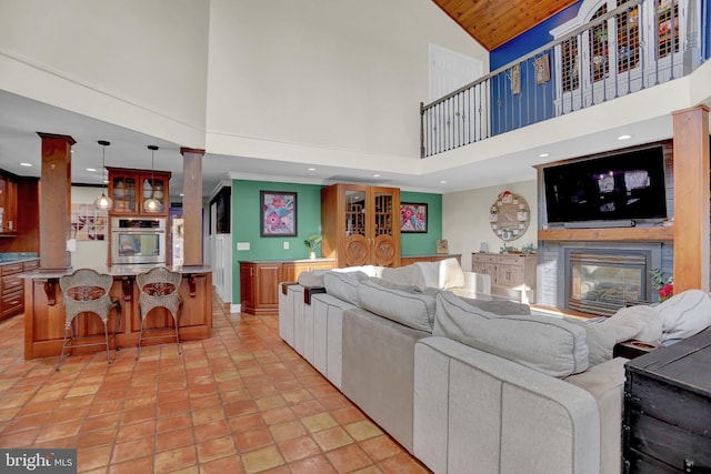 living room with decorative columns and a towering ceiling