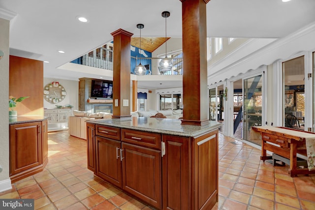 kitchen featuring ornamental molding, light stone counters, plenty of natural light, and pendant lighting